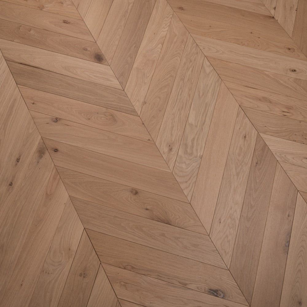 Chevron parquet wood flooring in light oiled finish with diagonal plank arrangement.