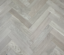 Engineered herringbone wood floor planks in light oak tones with visible grain