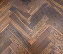 Engineered herringbone wood flooring with mixed wood-grain pattern and staggered planks
