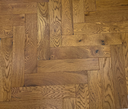 Engineered wood herringbone floor with wide plank layout and harvest wheat tone