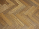 Smoked herringbone engineered wood flooring in warm golden-brown tones