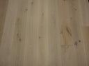 Unfinished engineered wood flooring in light natural color, plank layout with knots
