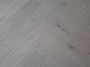 White oiled herringbone wood flooring with V-shaped plank pattern