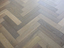 Engineered herringbone wood flooring in smoke grey with alternating plank pattern