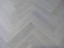 Light white-oiled engineered wood floor with herringbone plank pattern and click-fit seams