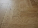 Brushed matt lacquered herringbone wood flooring, light natural finish with knots