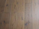 Engineered light brown wood planks with hand-scraped brushed finish and varied grain