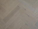 White oiled herringbone wood flooring showing diagonal V plank layout