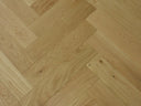 Herringbone wood flooring in pale beige oak with diagonal plank pattern and grain