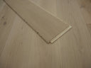 Unfinished engineered wood flooring plank end showing click-lock edge and light grain