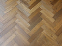 Smoked herringbone engineered wood flooring with mixed grey and amber planks