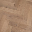 Light oak herringbone wood flooring with visible knots on brushed matte surface