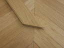 Natural chevron wood flooring edge detail with stepped V-shaped seam
