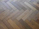 Engineered herringbone wood flooring with cool grey weathered plank tones