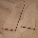 Light oak herringbone wood floor planks and metal alignment guide on boards