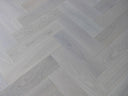 Light white-oiled engineered wood flooring with herringbone boards and visible plank grain