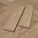 Light wood herringbone flooring boards laid out, showing matching end-joint edges