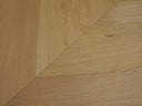 Natural wood chevron flooring close-up showing V-shaped plank joints