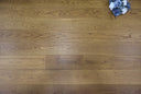 Golden wheat wood flooring planks with brushed matt texture and detailed grain