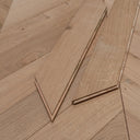 Unfinished light wood chevron flooring board pieces, edges and end grain visible