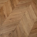 Natural oak chevron wood flooring with herringbone parquet pattern, close-up