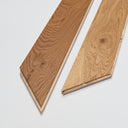 Engineered chevron wood flooring board ends with beveled edges, natural oak tone
