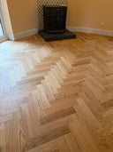 Natural oak herringbone engineered wood flooring in a room, parquet-style layout