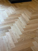 Natural oak herringbone engineered wood flooring, wide view of alternating plank tones