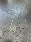 Gray engineered herringbone wood flooring planks, close-up staggered pattern