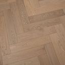 Light oak herringbone wood flooring section, visible wood grain and seams