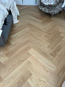 Light wood-look herringbone flooring with brushed matt finish, wide plank view