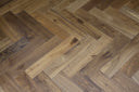 Smoked engineered wood flooring with brushed herringbone pattern, warm tan and brown planks