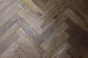 Smoked engineered wood flooring with brushed herringbone pattern, mixed gray-brown tones