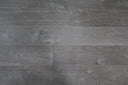 Close-up of soft grey engineered wood flooring with fossil stone finish and plank seams