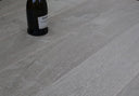 Soft grey engineered wood flooring with fossil stone look and subtle wood-grain pattern