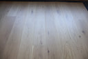 Engineered light grey wood floorboards with scattered knots