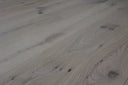 Light wood plank flooring with pronounced grain lines and knots, matte finish