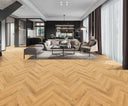 Natural oak herringbone laminate flooring across a living room floor, light tan wood