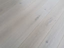 Light gray engineered wood flooring planks with subtle blue knot details
