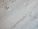 Whitewashed engineered wood flooring with blue-gray streaks and plank joints