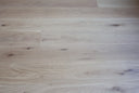 Engineered light grey wood flooring planks with visible grain and knots