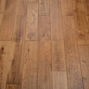Close-up of hardwood floor planks in light to medium warm brown with distinct grain