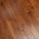 Handscraped solid wood flooring in warm golden brown with visible plank seams