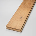 Stacked lacquered light wood planks with clear grain and knots