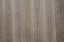Natural engineered wood plank with vertical woodgrain lines and subtle knots