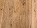 Natural oak-toned engineered wood floor with plank seams and knots