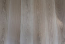 Pale oak engineered wood plank flooring with straight seams and grain texture
