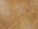 Golden smoke herringbone wood floor pattern with natural knots and swirling grain