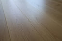 Light oak-look engineered wood flooring planks with clear grain, matte lacquer