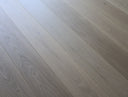 Pale gray engineered wood flooring with fine knots and straight wood grain streaks